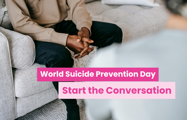 A photo of two people in a living room, their faces are cut off by the frame and we see the back of one and the hands of another folded across their lap. Text reads 'World suicide prevention day: start the conversation'