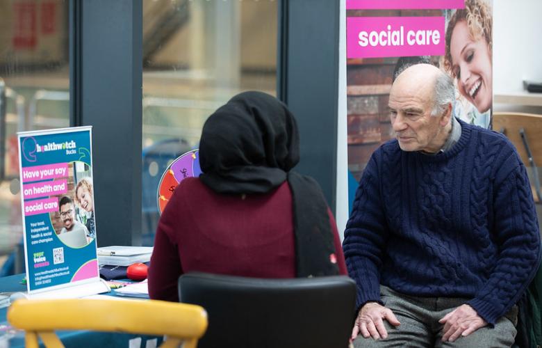 A photo of two people sat at an information desk