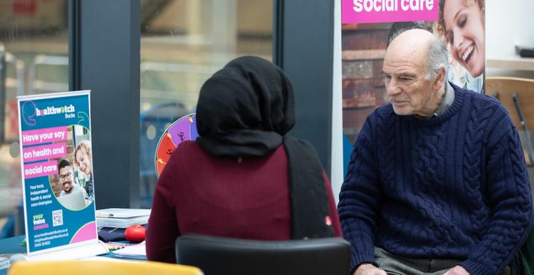 A photo of two people sat at an information desk
