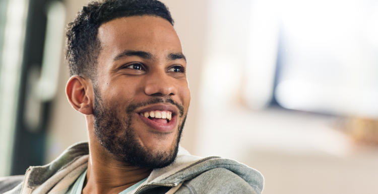 A photo of a smiling man looking at something out of frame
