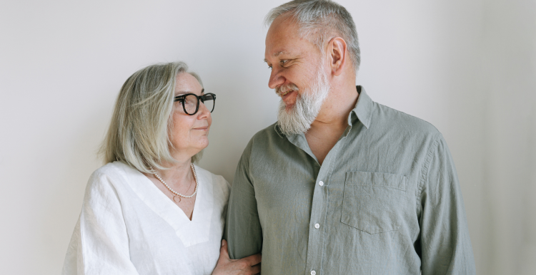 a photo of a mature couple stood side by side looking at each other.