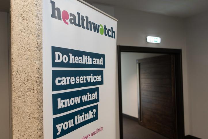 A photo of a pop-up Healthwatch banner. The banner has bold text that reads 'Do health and care services know what you think?'