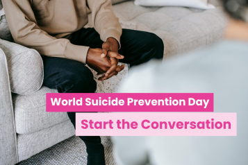 A photo of two people in a living room, their faces are cut off by the frame and we see the back of one and the hands of another folded across their lap. Text reads 'World suicide prevention day: start the conversation'