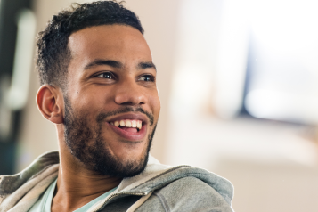 A photo of a smiling man looking at something out of frame