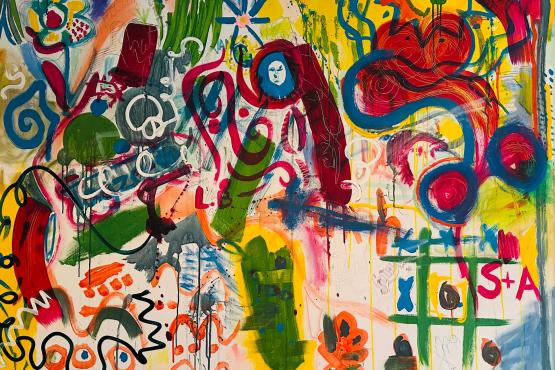 A photo of a canvas that has been expressively painted with bright colours and shapes.