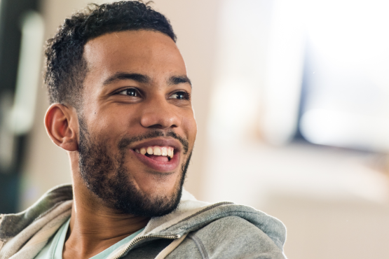 A photo of a smiling man looking at something out of frame
