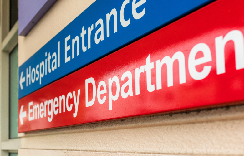 A photo of signs pointing to a hospital entrance and emergency department