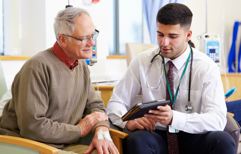A photo of a clinician showing an older patient something on a tablet